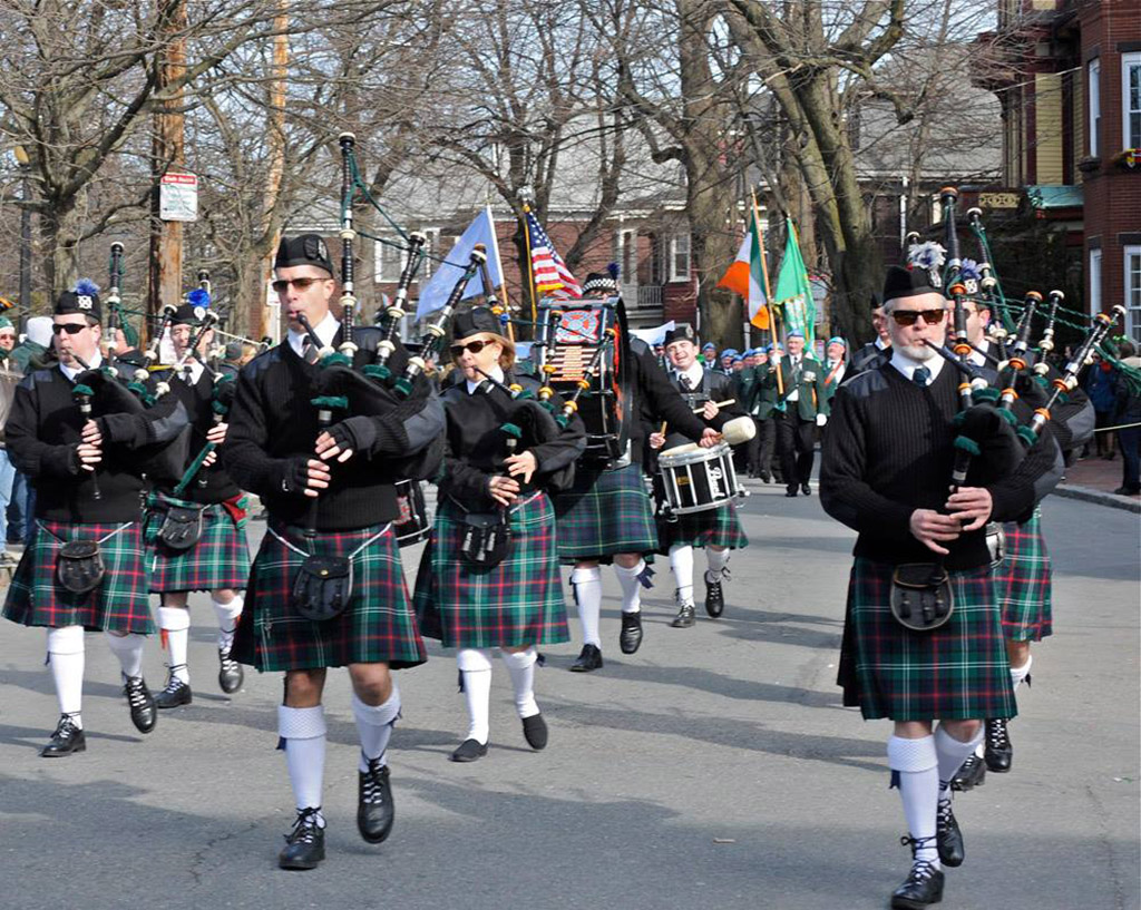 Men wearing kilts adn playing bagpipes for Boston's St. Patrick's Day Parade