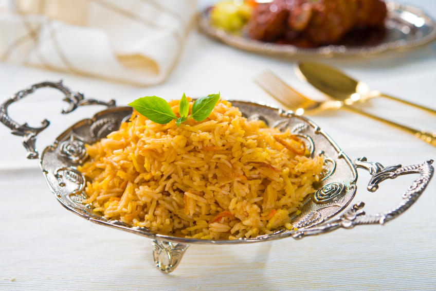 Indian chicken biryani on a silver platter garnished with mint