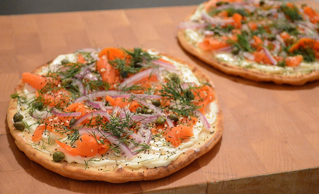 Flatbread with smoked salmon and cream cheese on a cutting board