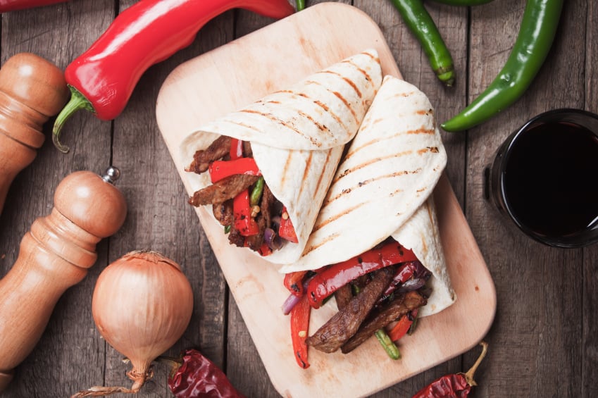 Fajitas on wooden board with vegetables