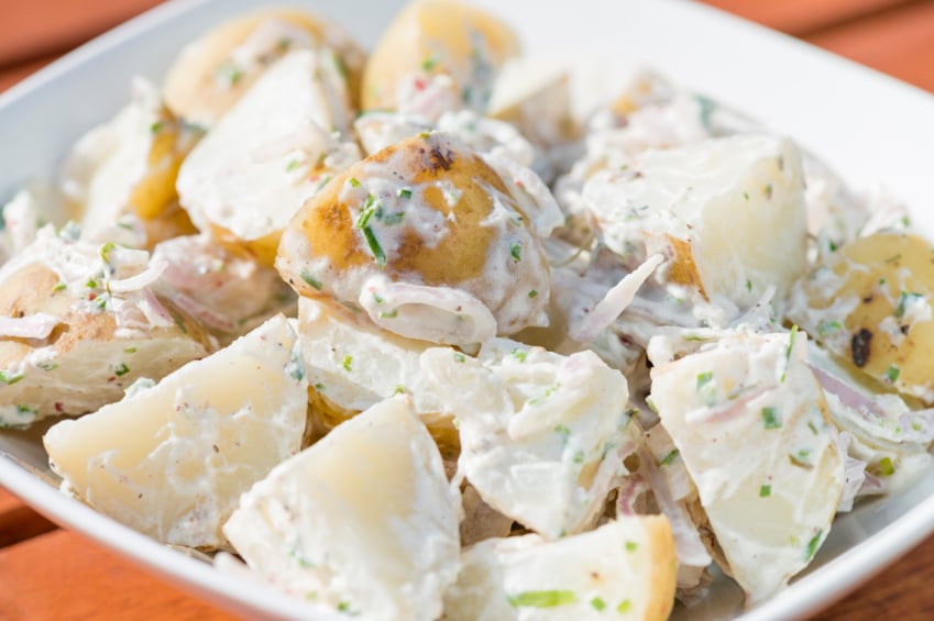 close-up of creamy potato salad with herbs and shallots