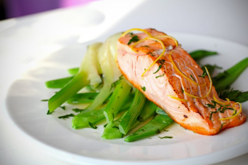 seared salmon with lemon zest and fennel on a white plate
