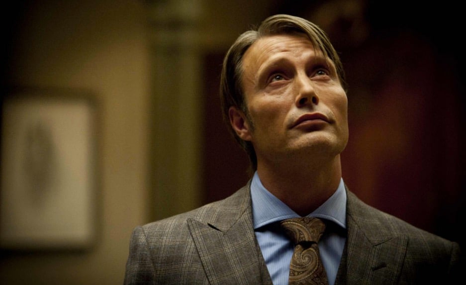 Mads Mikkelsen looks up while wearing a suit in a scene from NBC's Hannibal