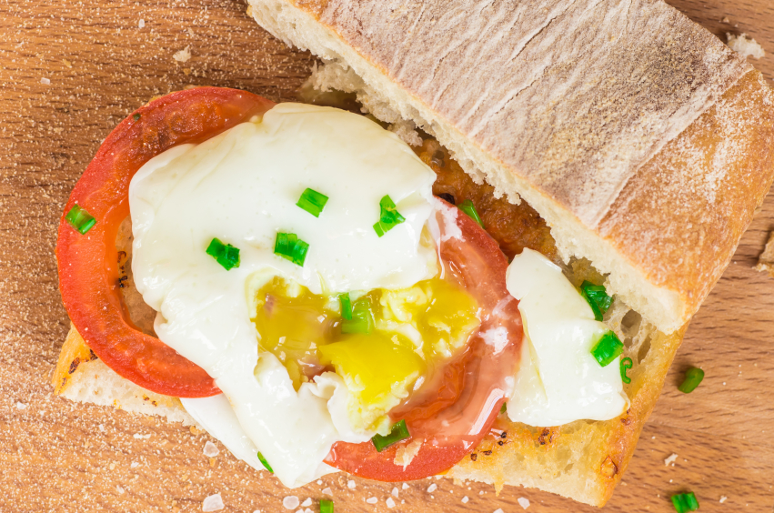 open ciabatta sandwich with tomatoes, chives, and a runny egg