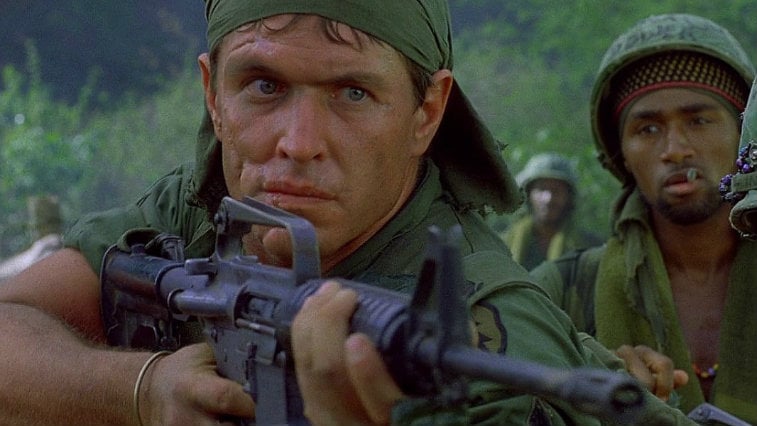 Tom Berenger holding a gun in Platoon.