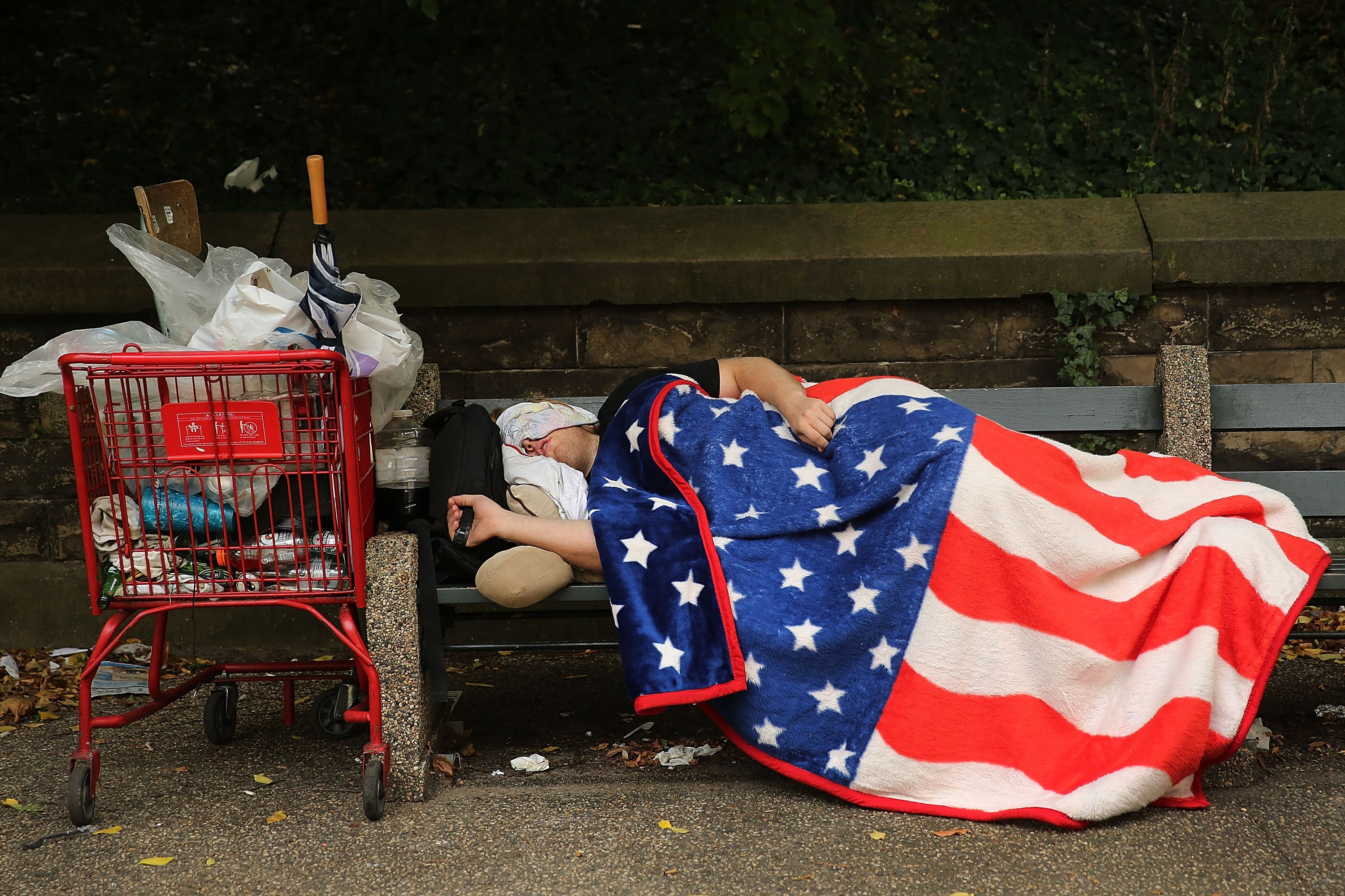 homeless man sleeping on bench 