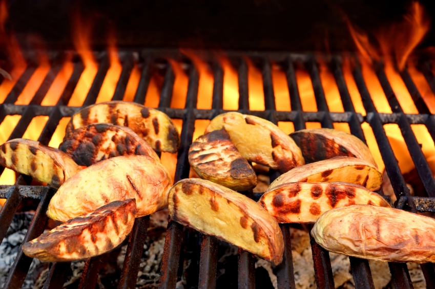 slices of potato on the grill with flames