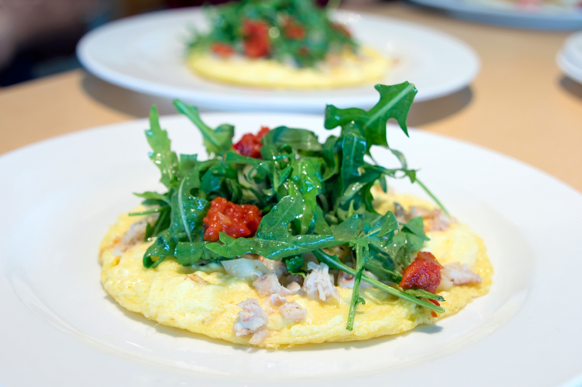 flat omelet with an arugula salad and crab topping