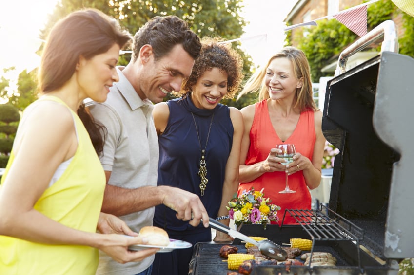 Friends hanging out around the grill at a cookout