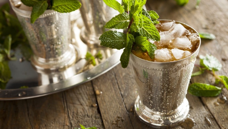 ming julep in a silver cup on a wooden table