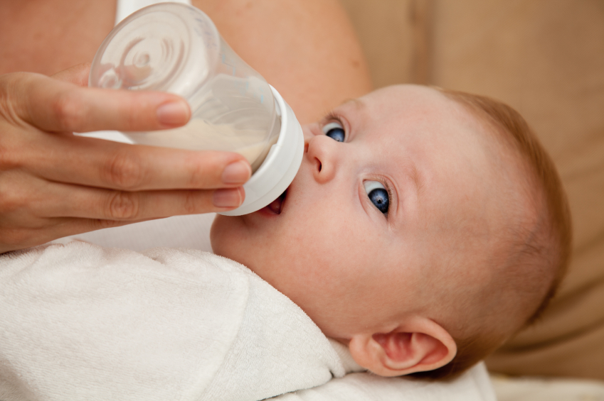 close-up image of a baby drinking out of a bottle