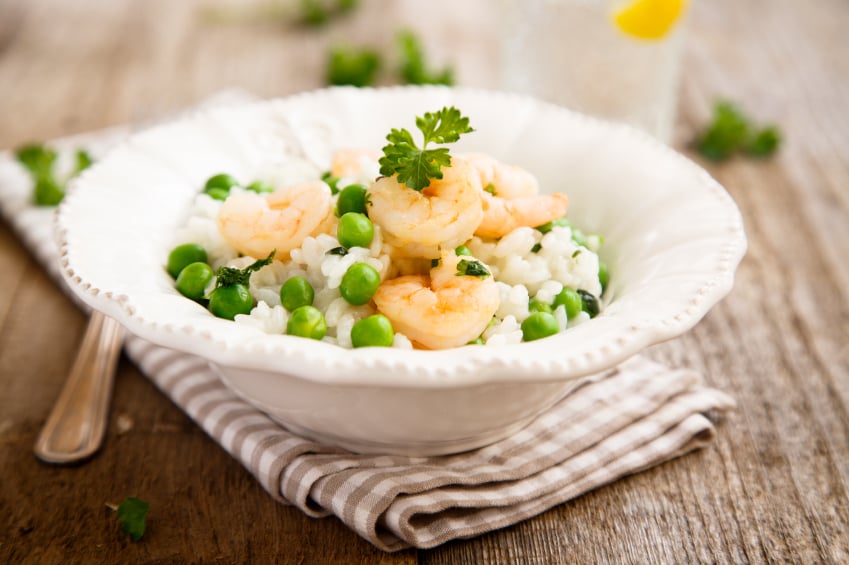 fancy white bowl filled with rice, green peas, and rice