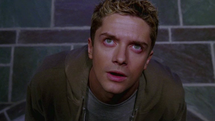 Topher Grace in Spider-Man 3, looking straight up and wearing a brown jacket