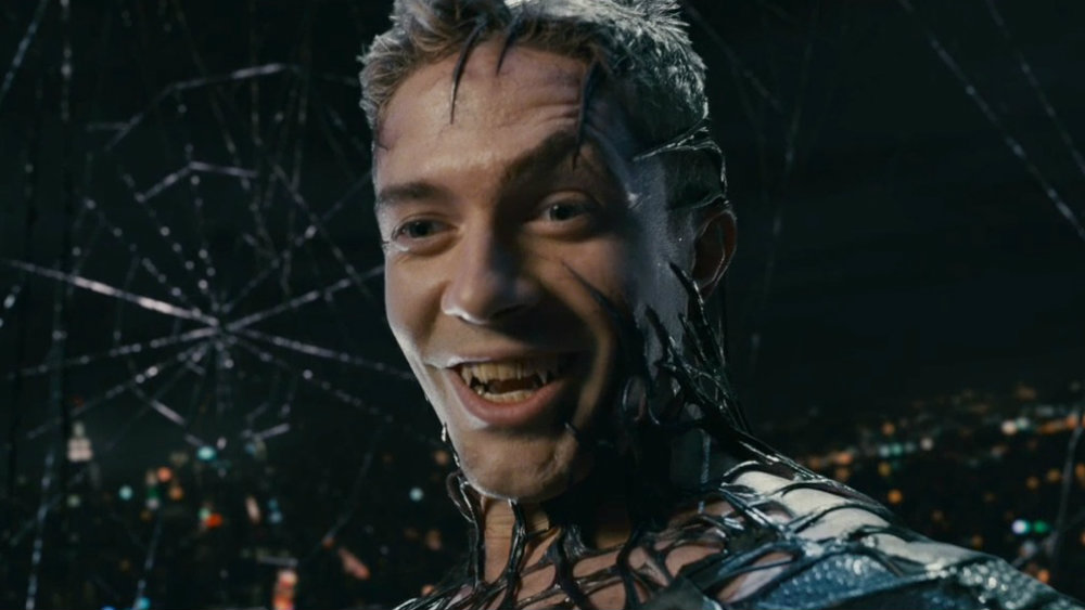 Topher Grace as Venom covered in black webbing in front of the night skyline in Spider-Man 3