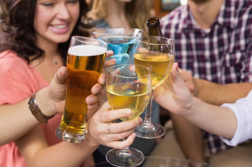group of four friends clinking alcoholic beverages