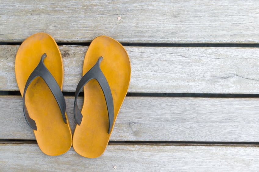 brown flip-flop sandals on a wooden background