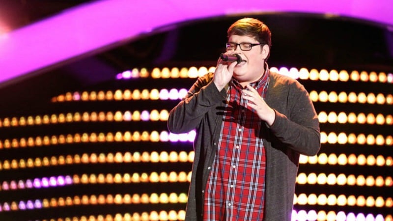 Jordan Smith has his eyes closed and is singing into a microphone on The Voice.