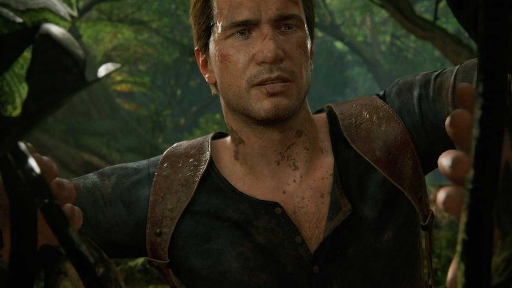 Uncharted's Nathan Drake peeks through foliage in a jungle.