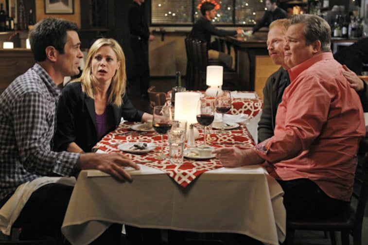 Julie Bowen, Ty Burrell, Jesse Tyler Ferguson and Eric Stonestreet sit at a restaurant table in Modern Family