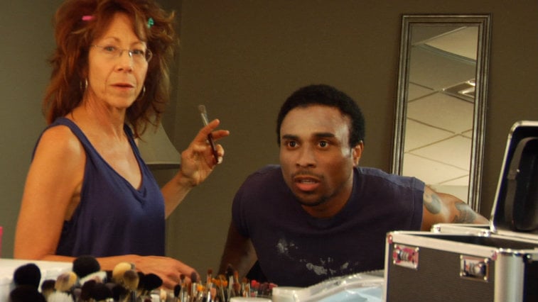 Mindy Sterling does Richard Pierre-Louis' makeup as he looks in a mirror