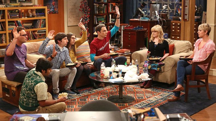 The cast of The Big Bang Theory sit around a table 
