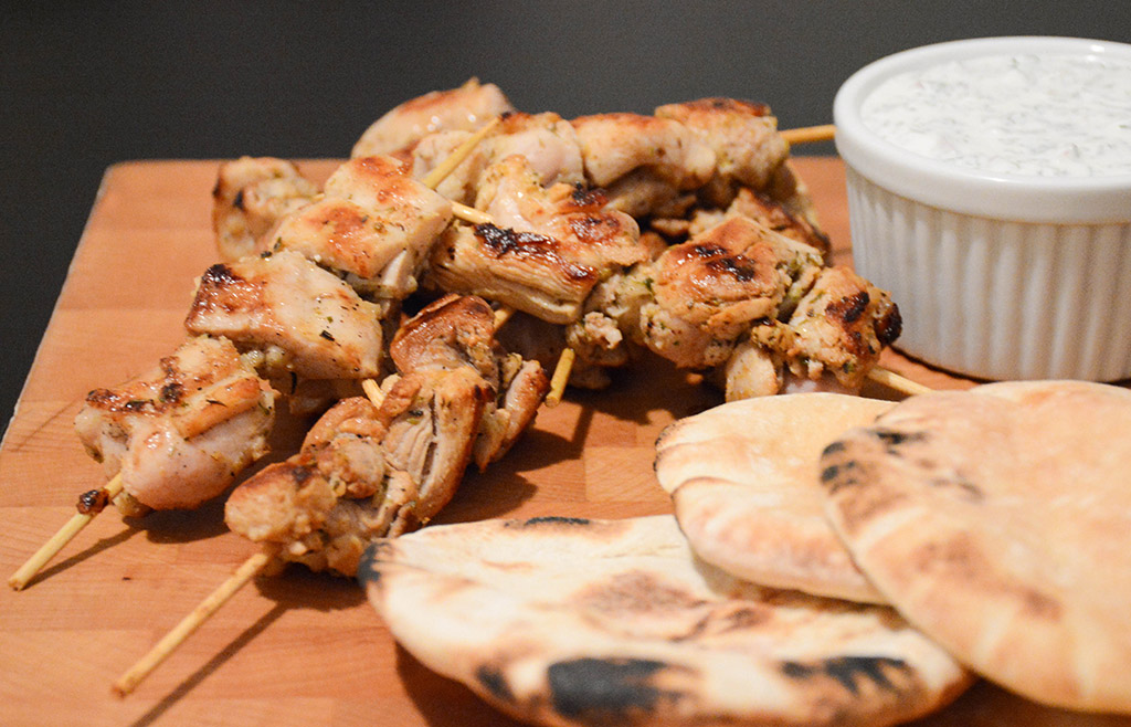 close-up of chicken souvlaki skewers with pita