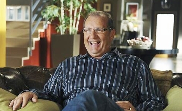 Ed O'Neill sits on a couch in Modern Family
