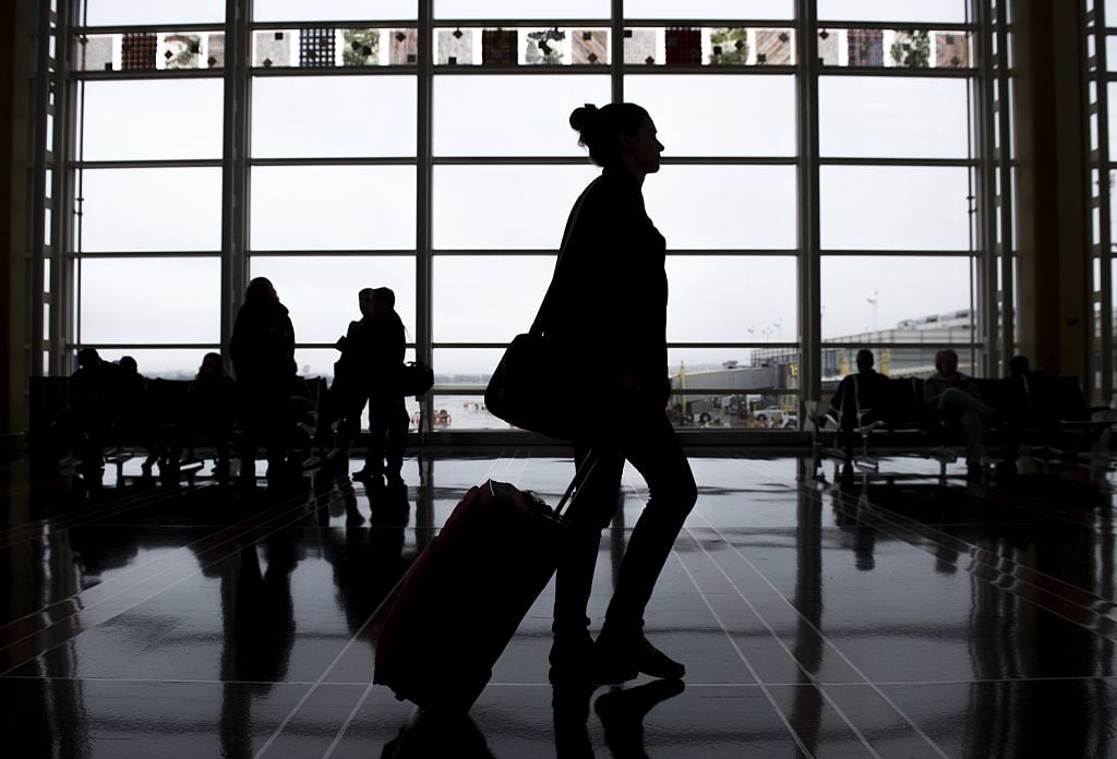 woman walks through the airport with luggage