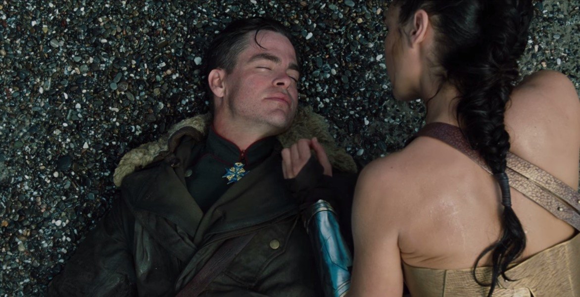 Steve Trevor laying on the beach as Diana hovers over him Steve Trevor laying on the beach as Diana hovers over him