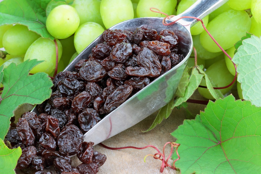 Spoon with raisins and green grapes