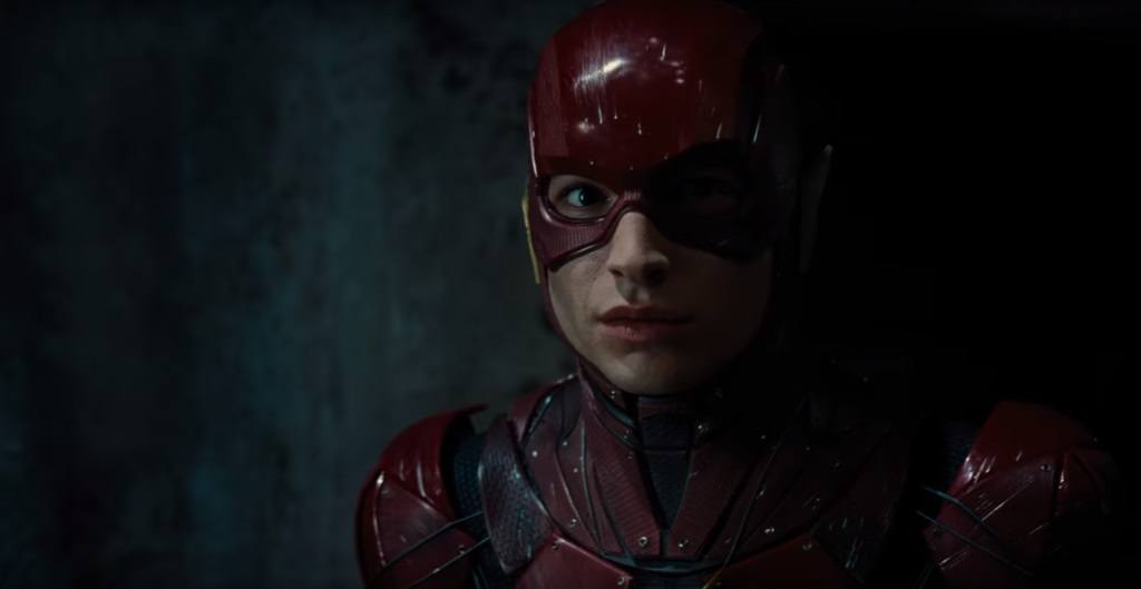 The Flash stands in a darkened room in his suit in Justice League