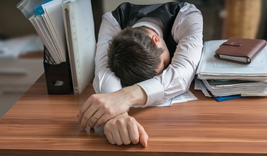 man sleeping on office desk