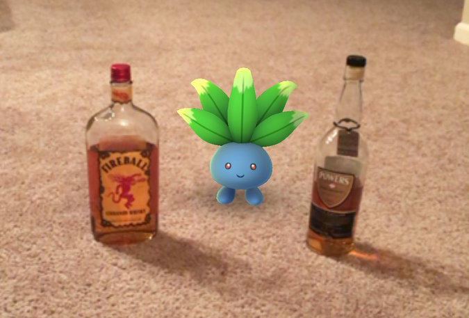 A Pokemon sits between bottles of liquor.