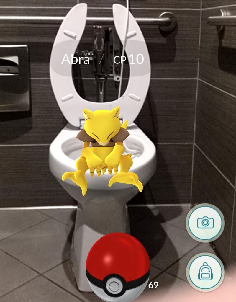 A Pokemon sits on a toilet.