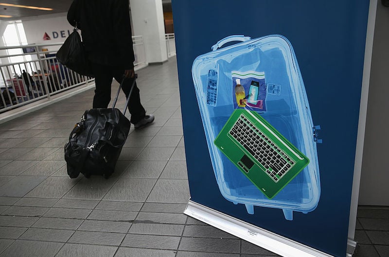 A traveler walks past a newly-opened TSA Pre-check application center at Terminal C of the LaGuardia Airport on January 27, 2014 in New York City. Once approved, travelers can use special expidited Precheck security lanes. They can also leave on their shoes, light outerwear and belt, as well as keep their laptop and small containers of liquids inside carry-on luggage during security screening. The TSA plans to open more than 300 application centers across the country.