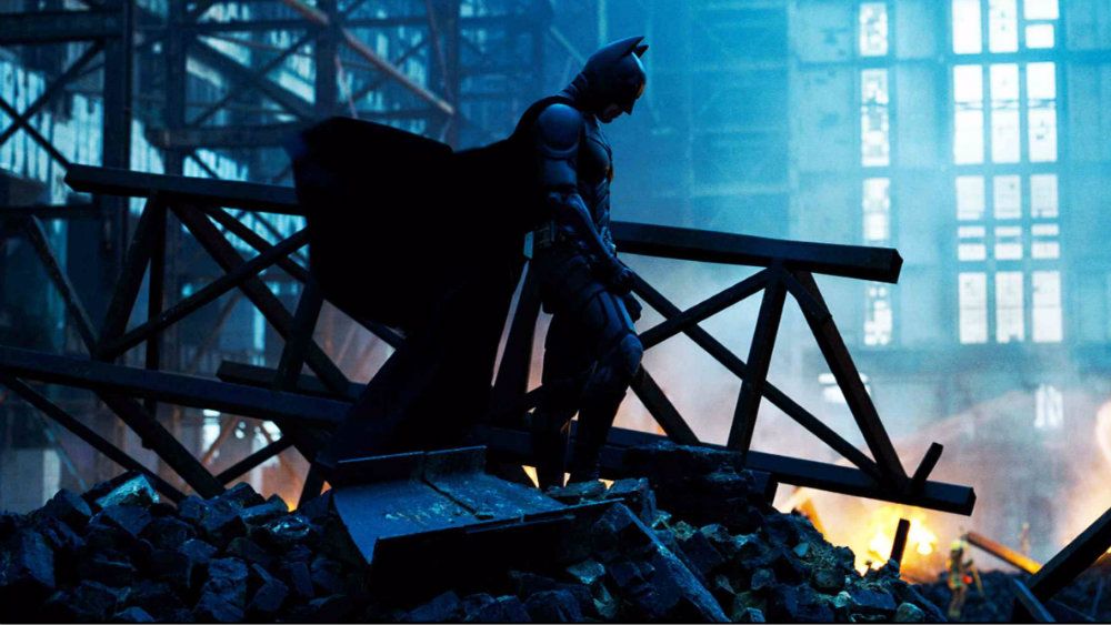 Batman is standing on a head of rubble in The Dark Knight.