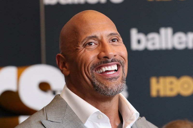 This is a closeup of Dwayne Johnson smiling on the red carpet.