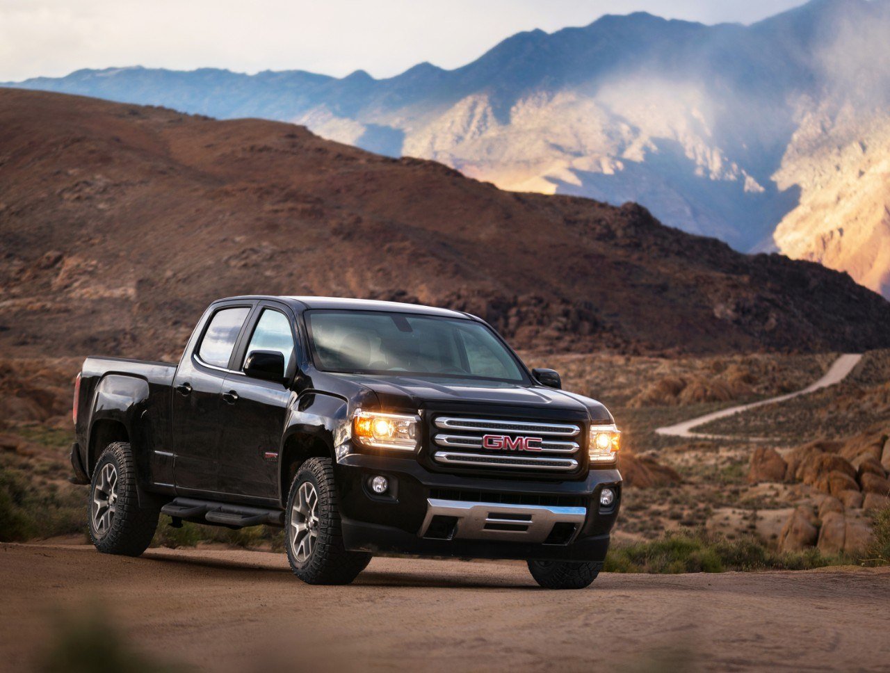 A black GMC Canyon parked on a scenic mountain range