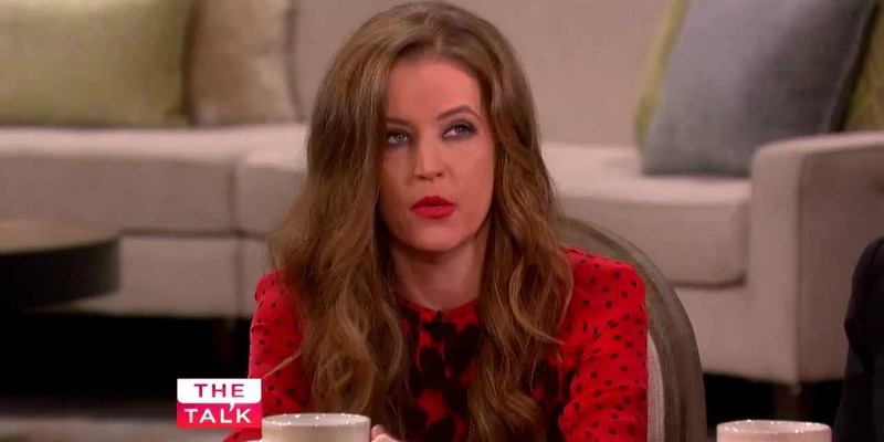Lisa Marie Presley is talking and holding a coffee mug on The Talk.