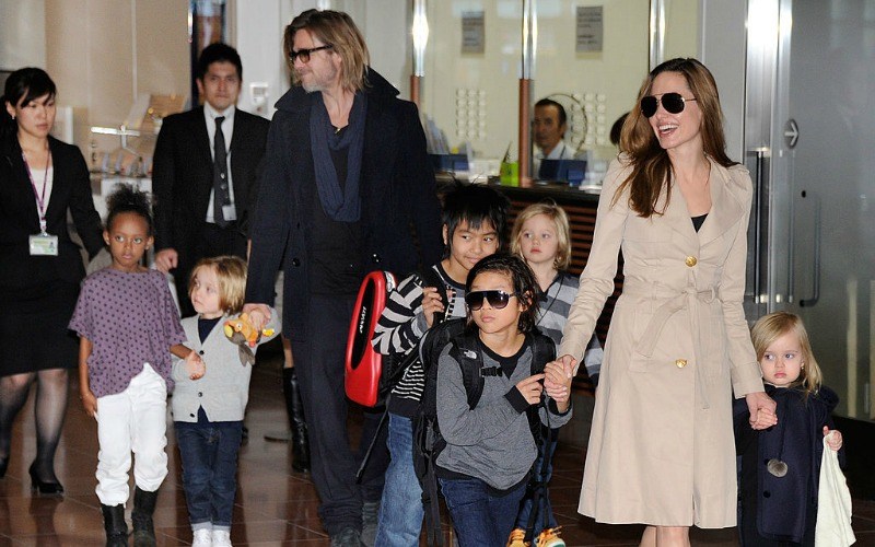 Brad Pitt and Angelina Jolie walk with their kids through an airport