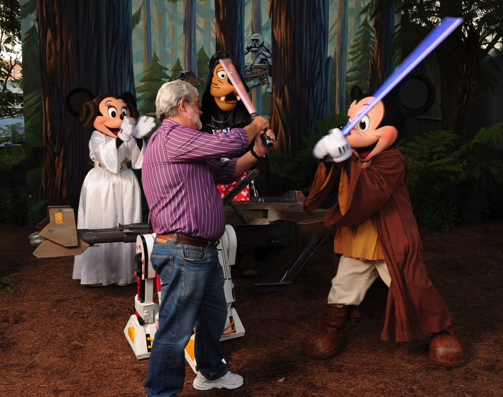 George Lucas has a playful lightsaber duel with Jedi Mickey Mouse