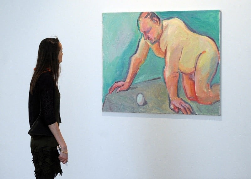 A woman looks at a painting in a Russian museum exploring body image issues