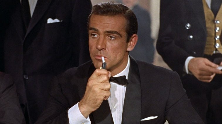 Sean Connery lights a cigarette while wearing a tux in Dr No 
