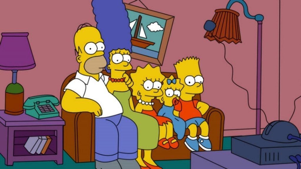 The Simpsons family sits on a couch, watching TV