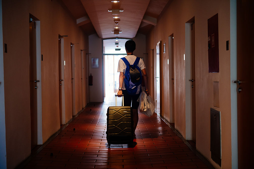 Man walking through a hotel with his bags