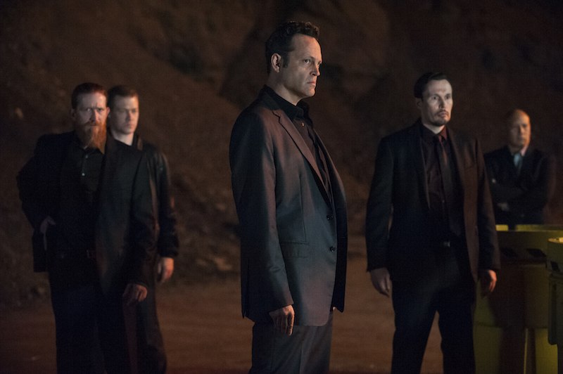 Vince Vaughn surrounded by men in black suits all looking angry on True Detective 