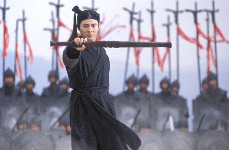 Jet Li holding a sheathed sword out in front of him, standing in front of troops in a line