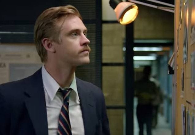Boyd Holbrook wears a suit and looks at a bulletin board in Narcos Season 2