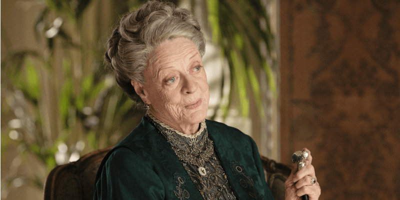 Maggie Smith sits in a chair in a scene from Downton Abbey