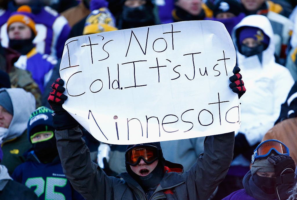 A Minnesotan holds up sign that reads: It's not cold. It's jut Minnesota.